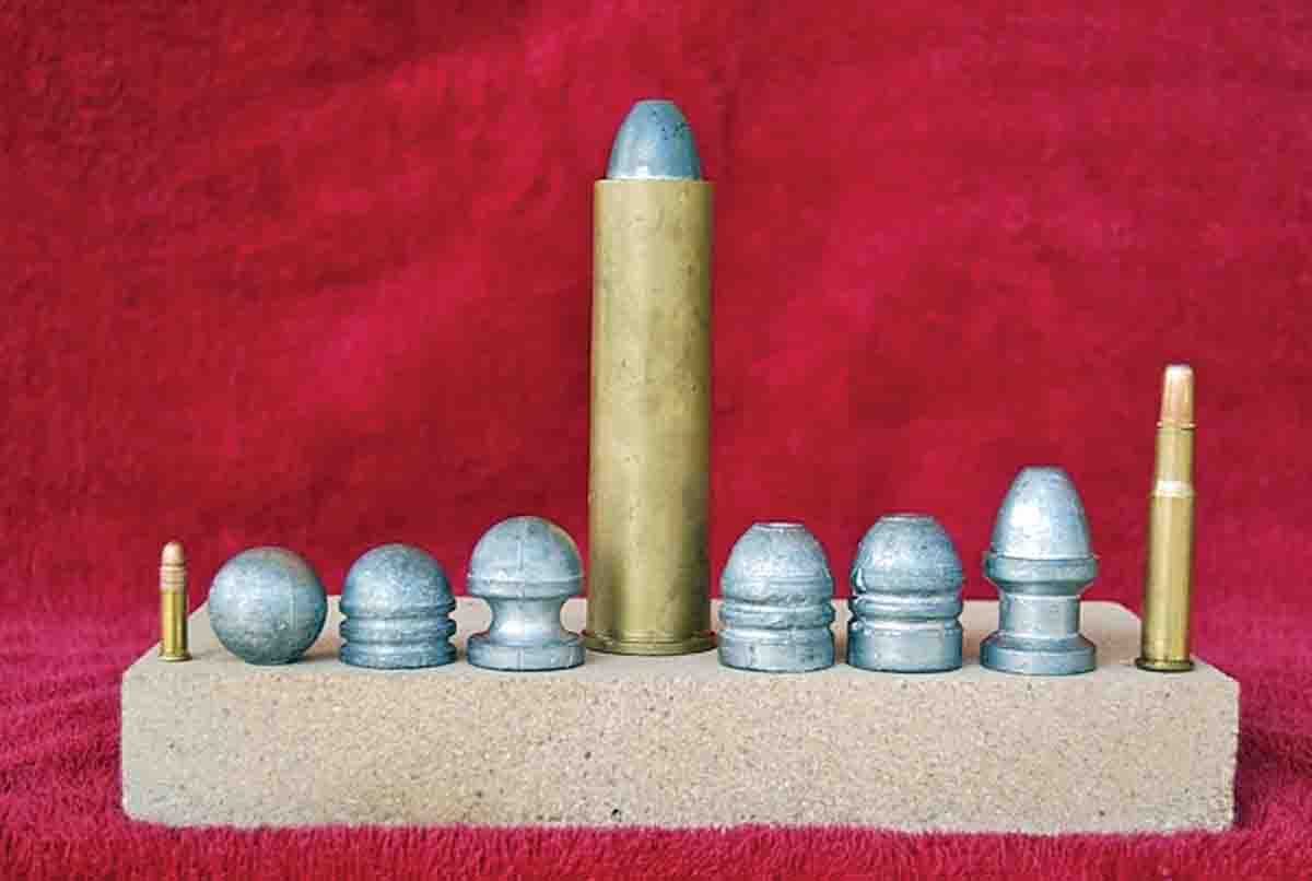 A 4-bore cartridge with a selection of suitable projectiles. The round ball on the left weighs 1,400 grains and the Paradox bullet on the right weighs 2,150 grains. A .22 rimfire cartridge (far left) and a .30-30 cartridge (far right) are shown for comparison.